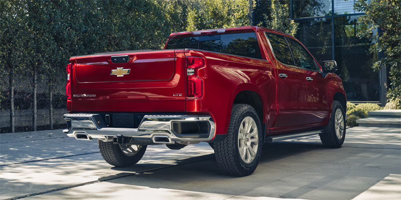 Red Chevrolet Silverado pickup truck parked in a driveway.